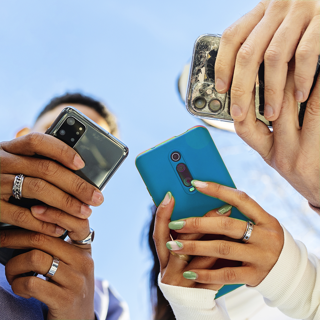 People holding their mobile phones.