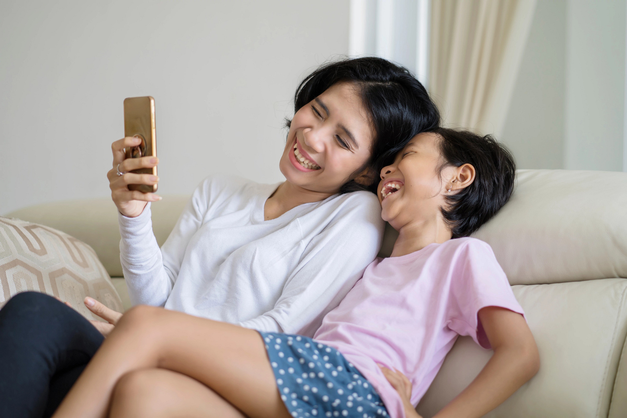 A parent and child using the phone together.