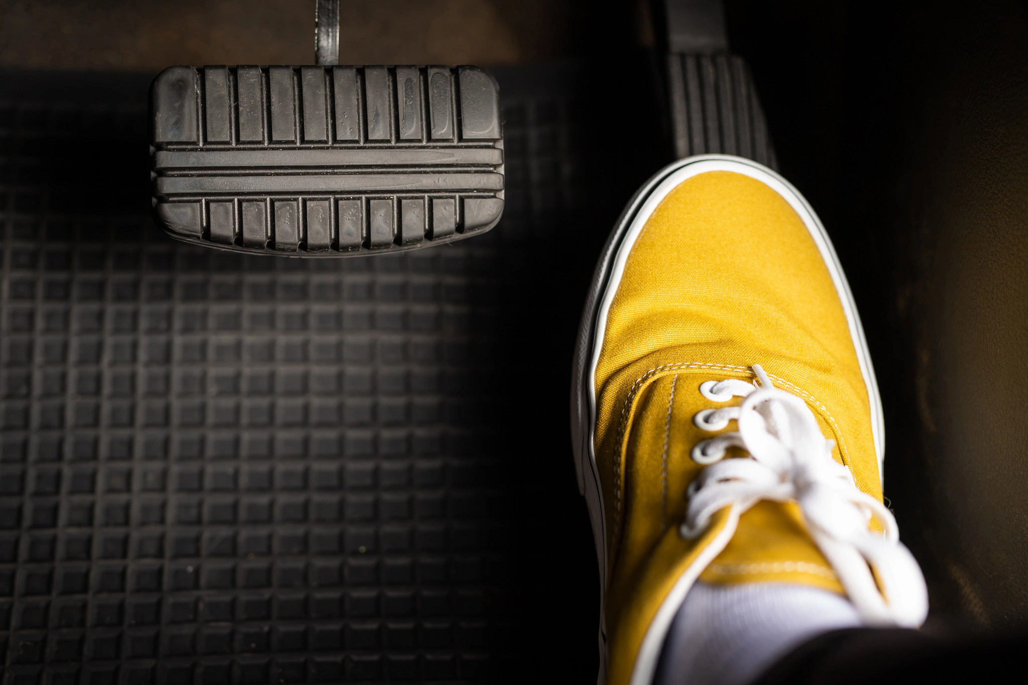 A person's foot pressing the accelerator pedal in a car.