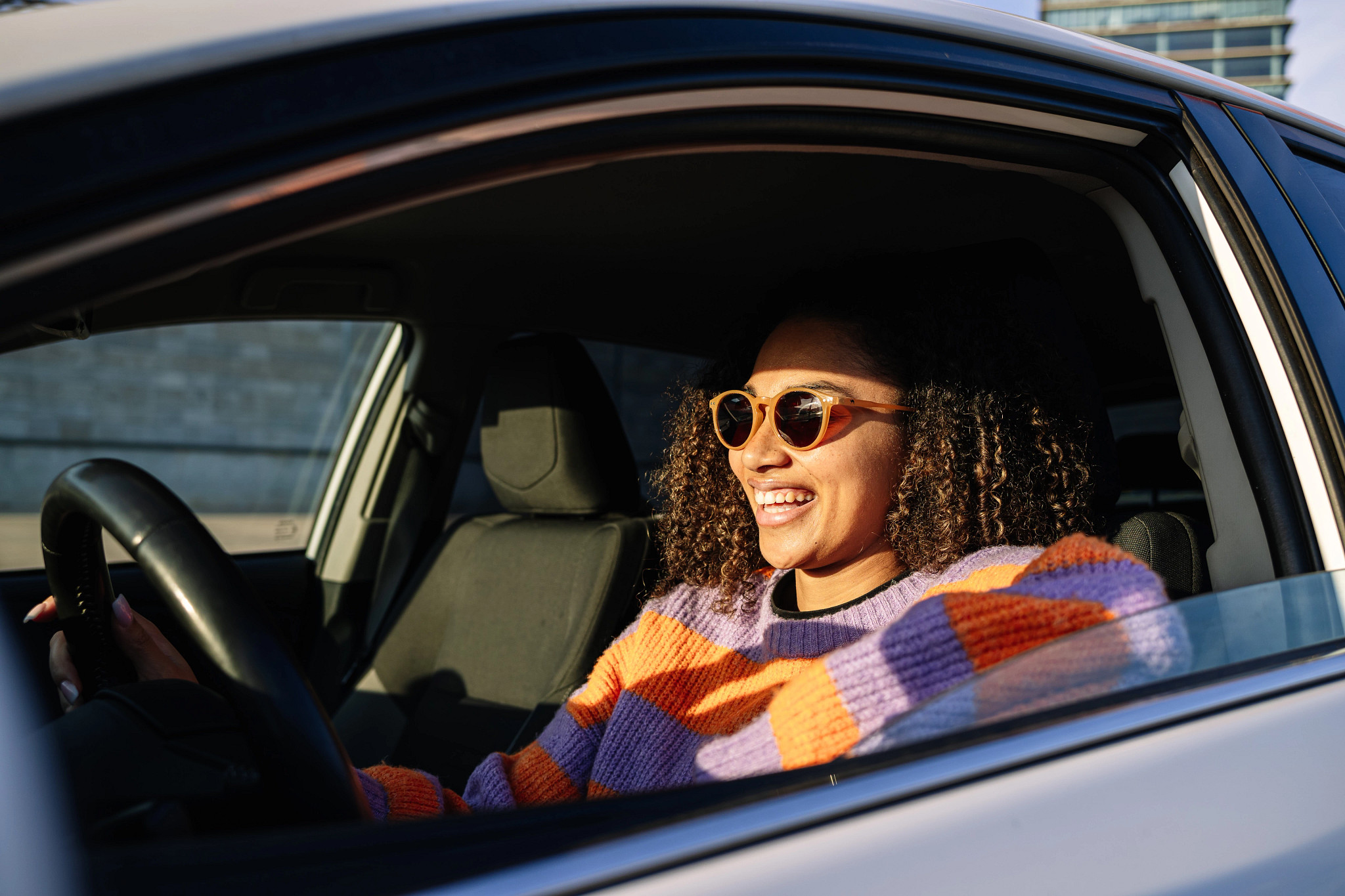 A woman behind the wheel of her car.