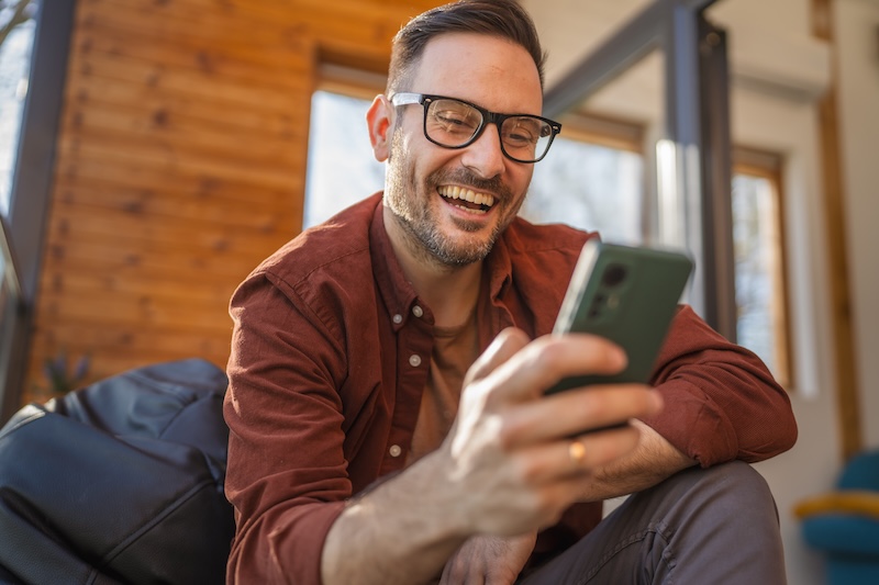 Man sitting while looking on his phone
