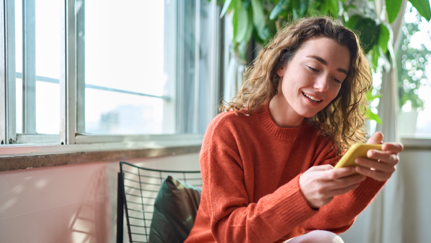 Personne assise sur une chaise lisant un message sur WhatsApp