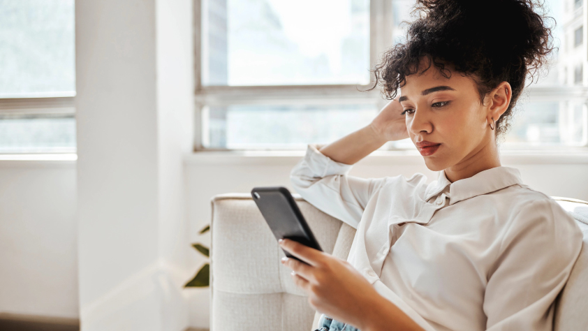 Person sitting on couch while reading a message via WhatsApp