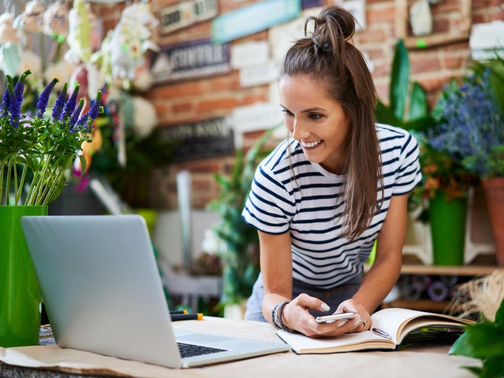 A woman in her flower shop looking at her laptop