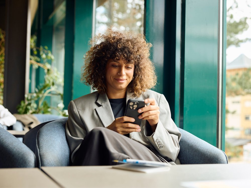 A woman in an office chair looking at her phone