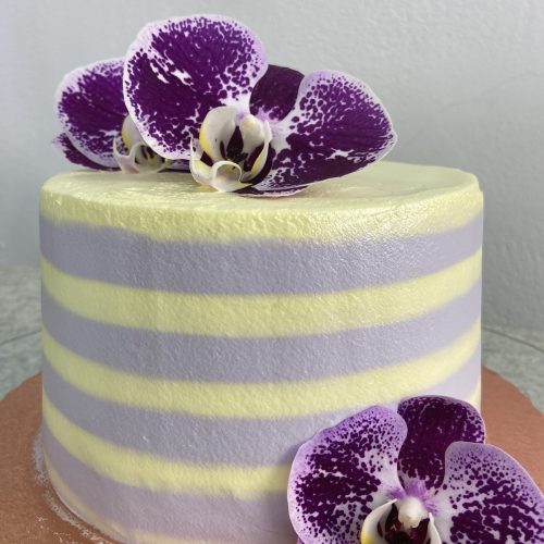 A layer cake with flowers on top.