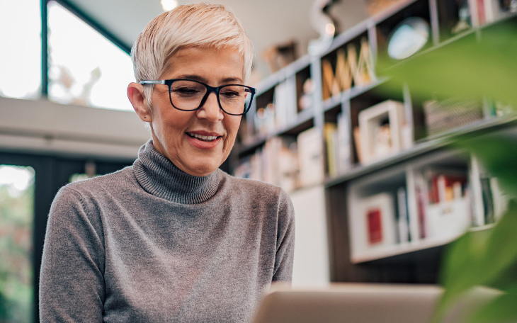 Personne portant des lunettes et travaillant sur un ordinateur portable chez elle