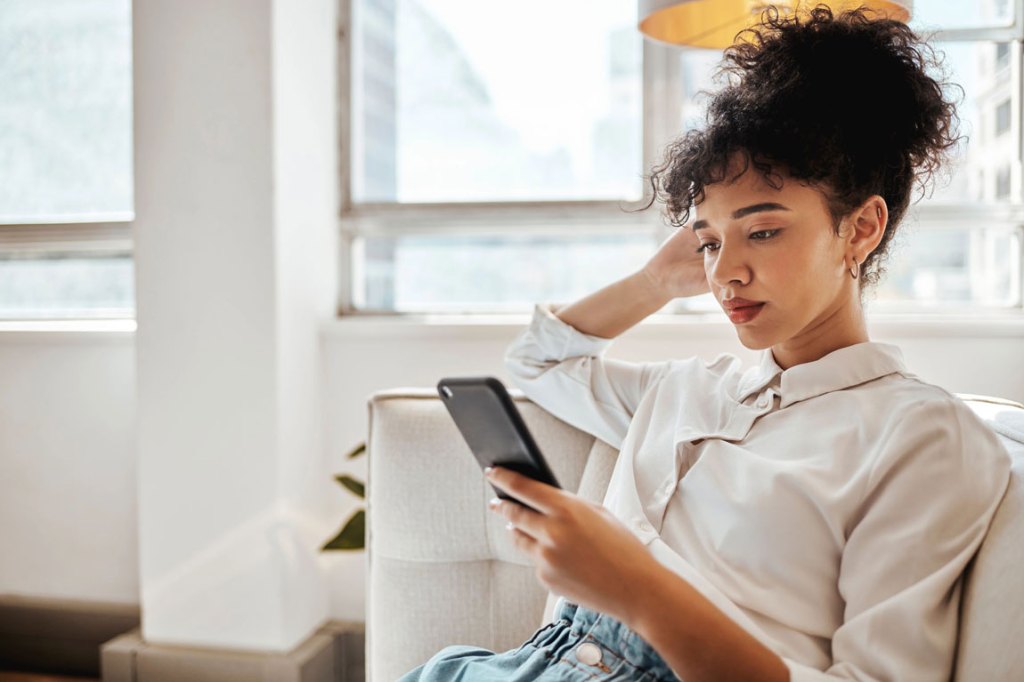 A woman looking at a text conversation