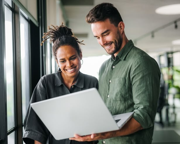 Man and woman standing and looking at a laptop