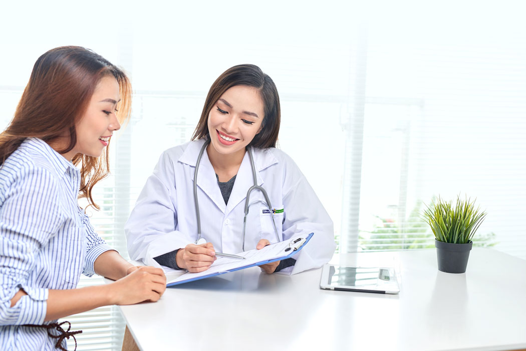 A smiling doctor presenting medical documents to a patient