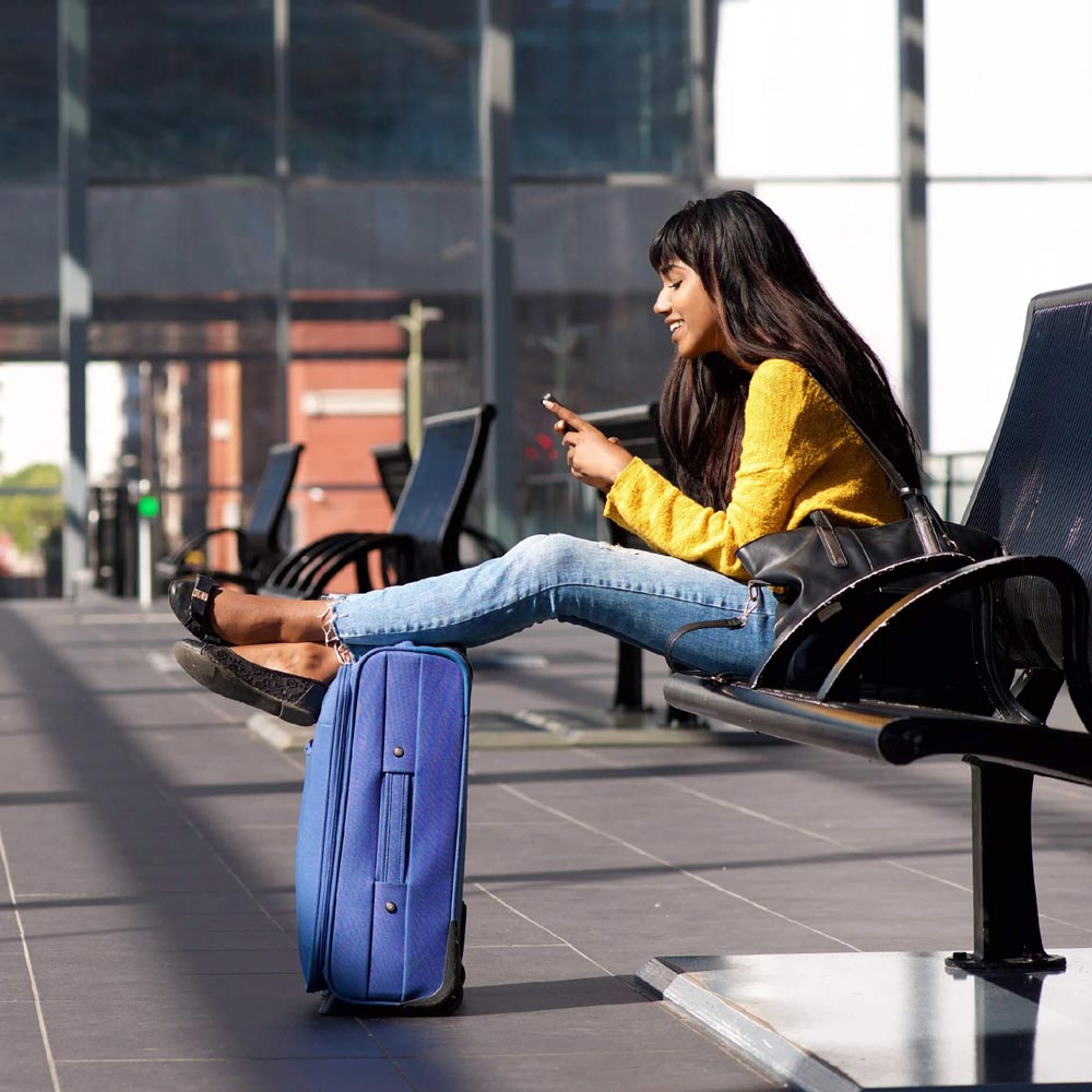 A woman sitting down and using her phone
