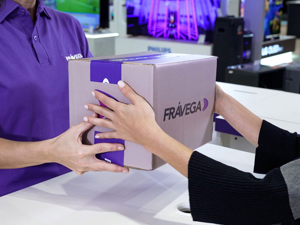 A Fravega employee handing over a box to a customer