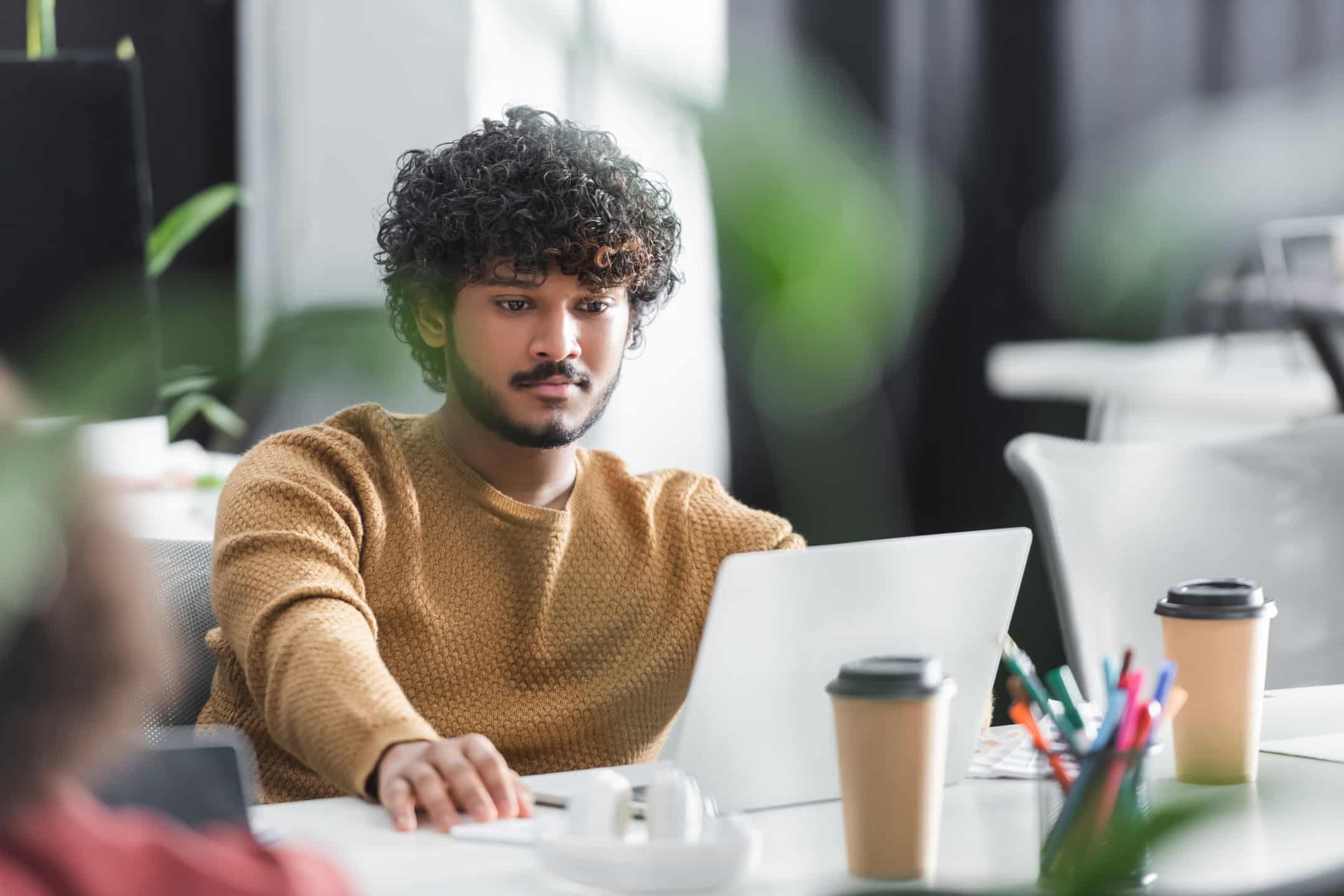 une professionnelle en train de parcourir sur son ordinateur portable les outils et fonctionnalités du service clientèle par discussion en direct de whatsapp business