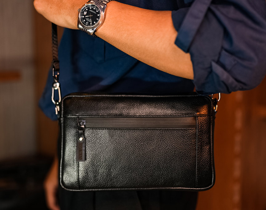 A man holding a leather bag.