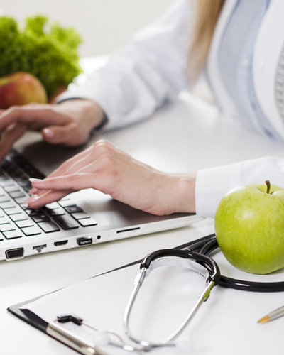 An apple on a woman's desk.
