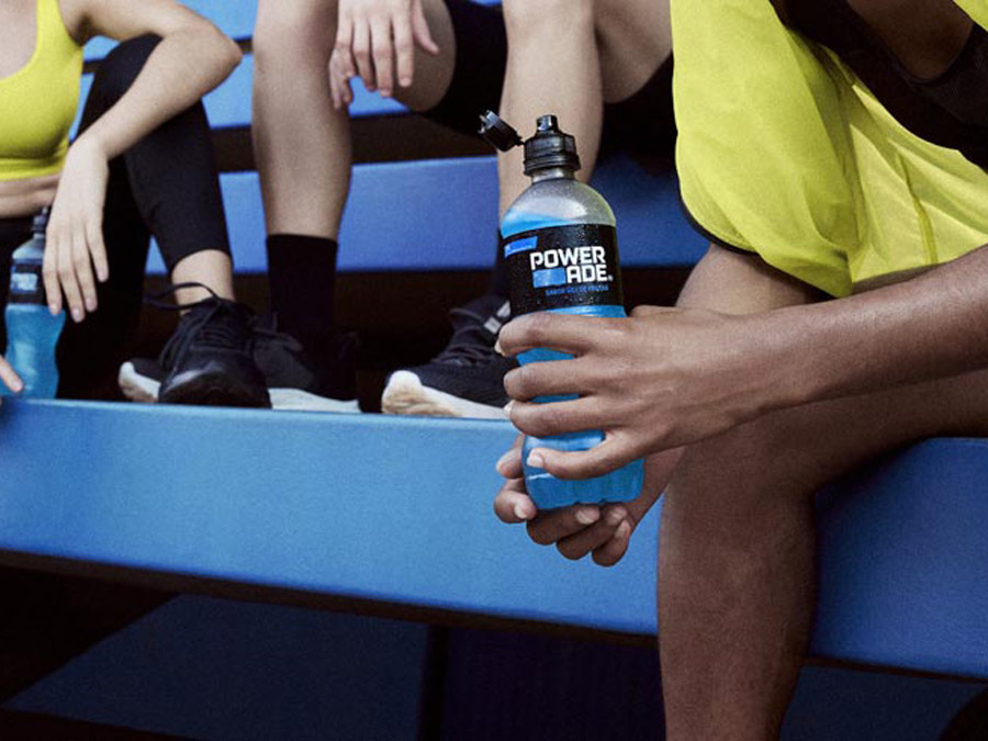 Un grupo de atletas sentados en las gradas beben Powerade.