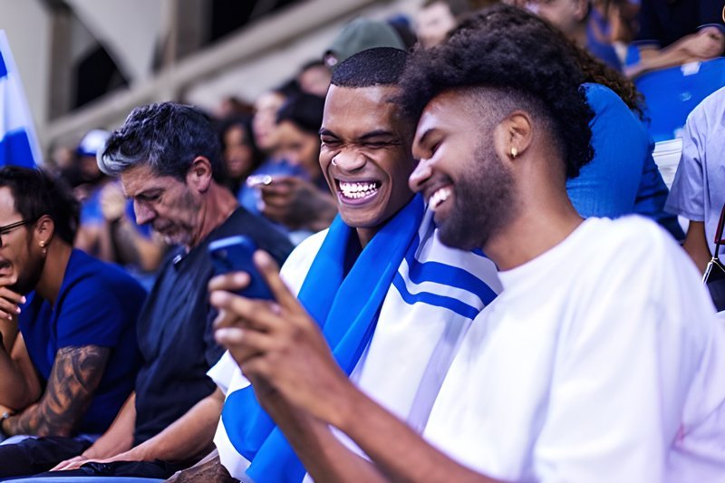 People looking at a phone at a football game