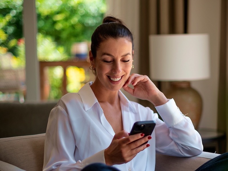 A smiling red haired women looking at her phone