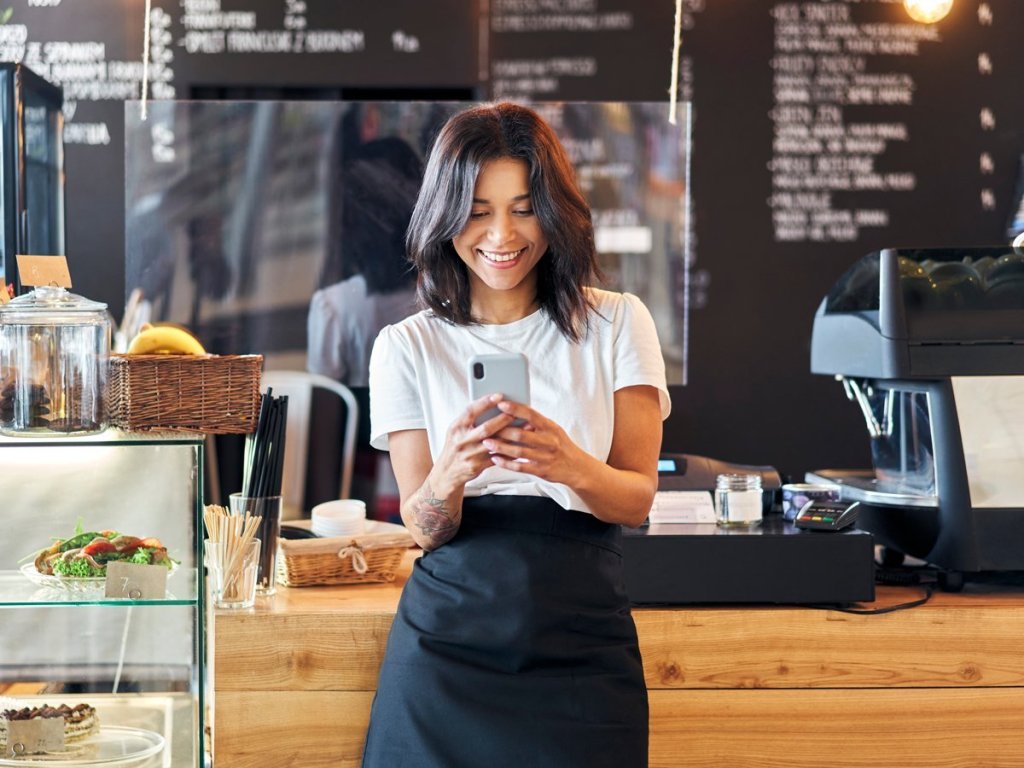 A woman working on her phone and smiling