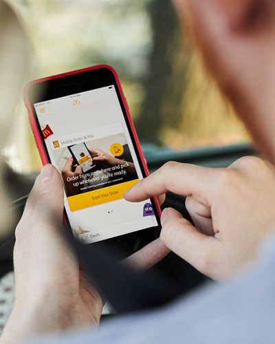 Person sitting in their car on the Arcos Dorados app about to start their order