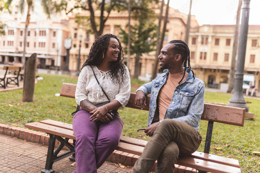 A man and a woman sitting on a bench having a conversation