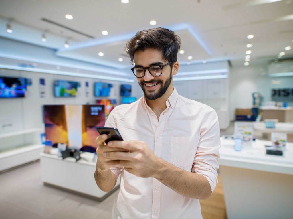 A man looking at his phone in a store