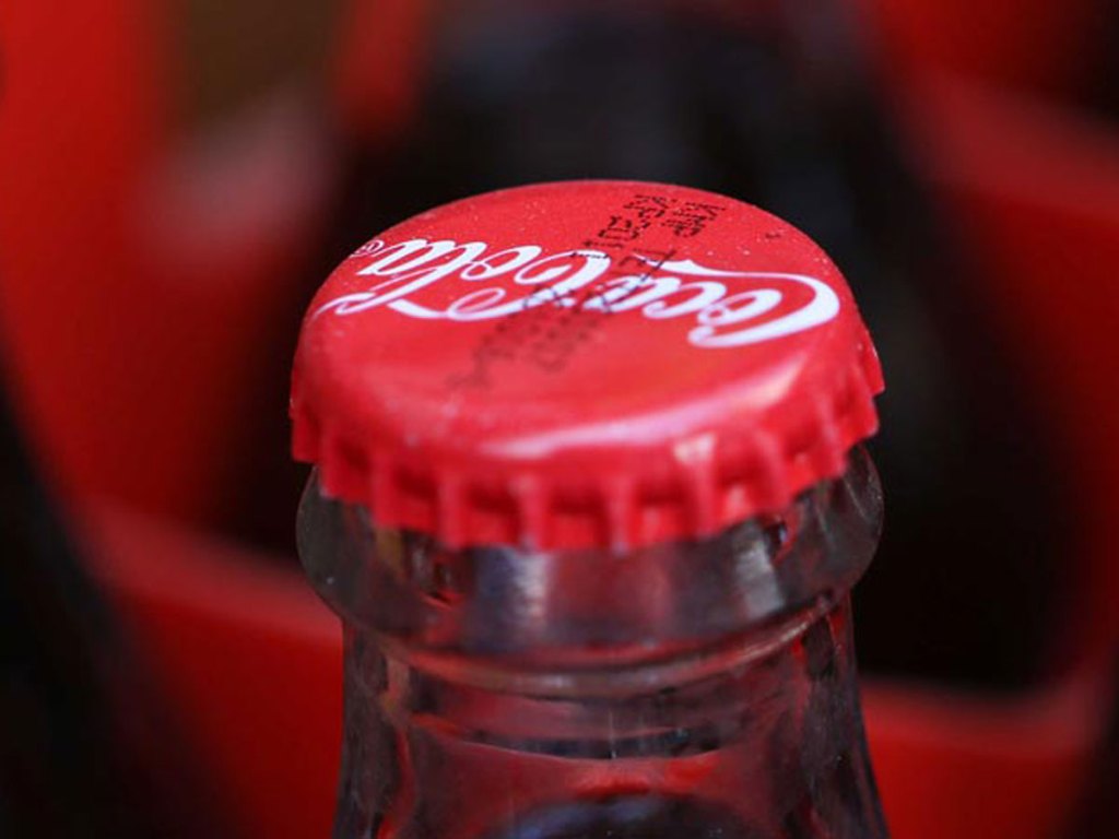 A close up of the top cap on a Coca-Cola bottle