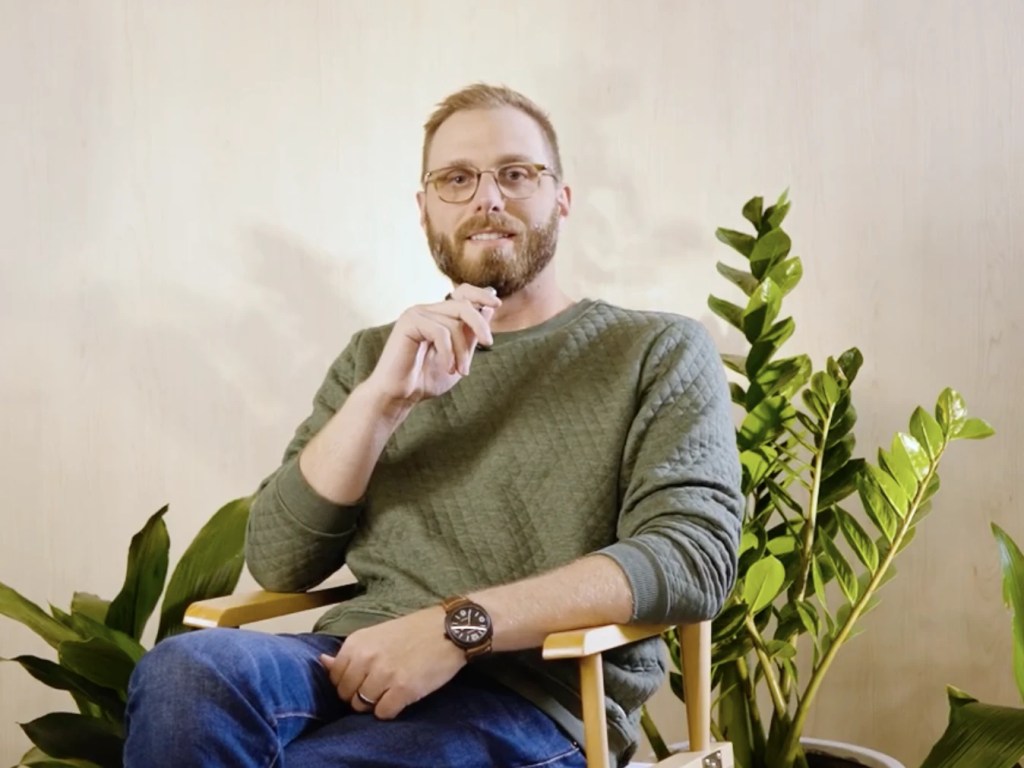 James Detmer sitting down holding a microphone
